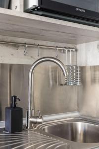 塞萨洛尼基Restored, immaculate condo @ historic center #1的厨房水槽设有水龙头和台面 更多15张照片