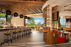 a restaurant with a bar with chairs and tables at Signia by Hilton La Cantera Resort & Spa in San Antonio