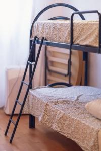 een zwart stapelbed met een ladder ernaast bij Sassari Station Inn in Sassari