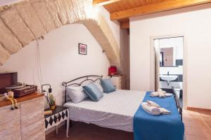 een slaapkamer met een bed met blauwe lakens en een wastafel bij Sassari Station Inn in Sassari