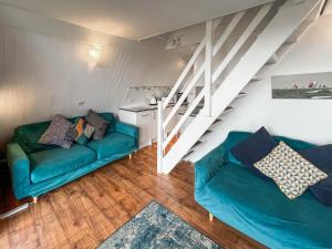 een woonkamer met twee blauwe banken en een trap bij Chalet Lodge - Uk51029 in Kingsdown