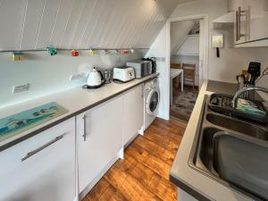 een keuken met een spoelbak en een wasmachine bij Chalet Lodge - Uk51029 in Kingsdown