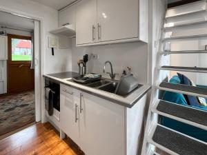 een keuken met witte kasten en een spoelbak bij Chalet Lodge - Uk51029 in Kingsdown