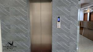 a elevator in a building with a sign on the wall at Heritage Stay Bagerhat in Bāgherhāt +12 photos
