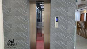 a glass elevator door with a cell phone on it at Heritage Stay Bagerhat in Bāgherhāt