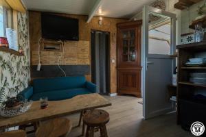 a living room with a blue couch and a table at Le panier bio de noé in Noé