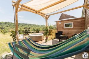 a hammock on a deck with a cabin at Le panier bio de noé in Noé