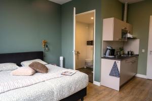 ein Schlafzimmer mit Bett und eine kleine Küche in der Unterkunft Short Stay Wageningen in Wageningen + 15 Fotos