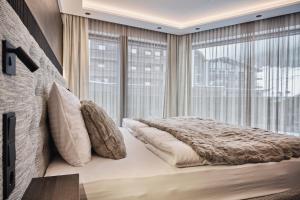 ein Schlafzimmer mit einem Bett und einem großen Fenster in der Unterkunft Chalet Ischgl - Modern Luxury Residences in Ischgl