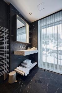 ein Badezimmer mit Waschbecken und Spiegel in der Unterkunft Chalet Ischgl - Modern Luxury Residences in Ischgl + 62 Fotos
