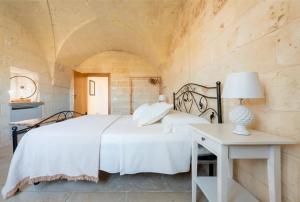 una camera da letto con un letto bianco e un tavolo di Antico Casolare P. P. a Otranto