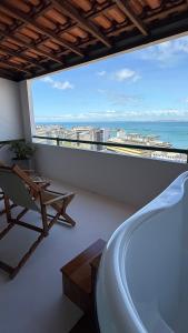 a balcony with a tub and a view of the ocean at Casa Versace Salvador - Colonial House in Salvador