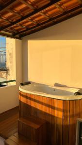 a bath tub in a room with a window at Casa Versace Salvador - Colonial House in Salvador +25 photos