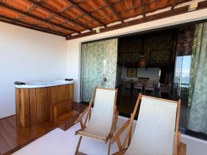 two chairs in a room with a tub and a table at Casa Versace Salvador - Colonial House in Salvador