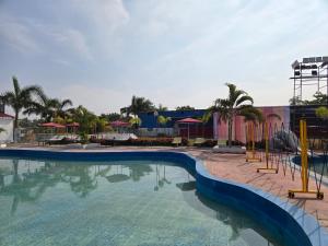 a swimming pool at a resort with a playground at Shyam Resort in Khandwa