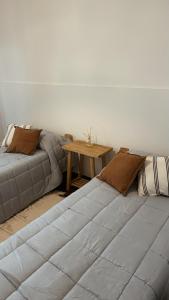 2 letti in una camera con tavolo in legno di Casa Soul a Chascomús