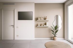 ein Wohnzimmer mit einer Tür und einem Fernseher an der Wand in der Unterkunft Vibra Tahiti Comfort in Lido di Jesolo