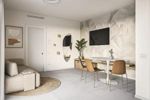 ein Wohnzimmer mit einem Tisch, Stühlen und einem Bett in der Unterkunft Vibra Tahiti Comfort in Lido di Jesolo