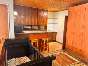 a large kitchen with wooden cabinets and stools in it at Tula@159 in Bloemfontein