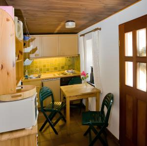 a kitchen with a table and chairs and a sink at Ferienwohnungen Appelhof in Pellworm