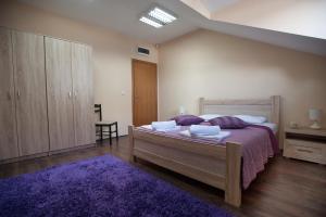 a bedroom with a large bed and a purple rug at Apartman in Danilovgrad +12 photos