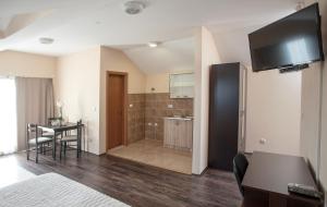 a bedroom with a bathroom with a sink and a table at Apartman in Danilovgrad