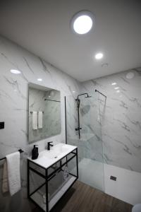 un bagno bianco con lavandino e doccia di Casa Avó Libânia a Murça