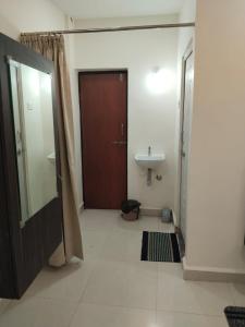 a bathroom with a wooden door and a sink at Prestige Palace in Mugad +11 photos