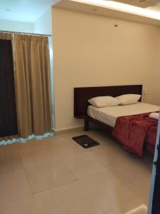 a bedroom with a bed and a window with a curtain at Prestige Palace in Mugad