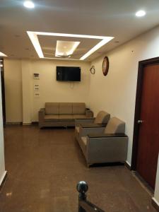 a waiting room with couches and a flat screen tv at Prestige Palace in Mugad