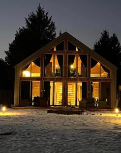 een groot huis met een grote glazen gevel 's nachts bij Krasne Residence & Spa - STREFA CISZY in Krasne