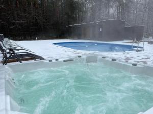 een jacuzzi in de sneeuw met een gebouw bij Krasne Residence & Spa - STREFA CISZY in Krasne