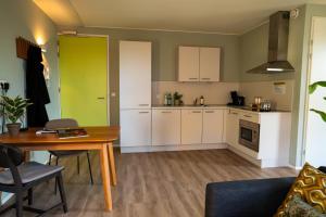 eine Küche mit weißen Schränken und einem Tisch im Zimmer in der Unterkunft Short Stay Wageningen in Wageningen + 8 Fotos