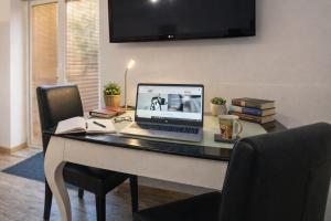 a desk with a laptop computer on top of it at Garden Studio with Kitchen & BBQ - KindStay Suites Prague Airport in Kněžívka
