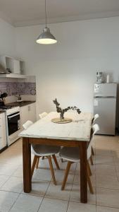 una cucina con tavolo in legno e sedie bianche di Casa Soul a Chascomús