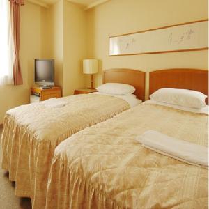 a hotel room with two beds and a television at Hotel Crown Hills Niigata in Niigata