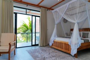 a bedroom with a bed with a mosquito net at Changarawe Hotel & Retreat in Pongwe