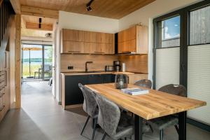 eine Küche und ein Esszimmer mit einem Holztisch und Stühlen in der Unterkunft Ferienhaus am See LEE - Vogteihof am Bodden in Streu