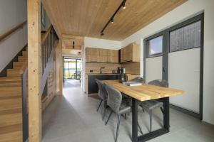 eine Küche mit einem Holztisch und Stühlen in der Unterkunft Ferienhaus am See LEE - Vogteihof am Bodden in Streu + 7 Fotos