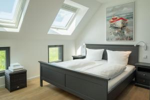 ein Schlafzimmer mit einem Bett und einem Bootsgemälde in der Unterkunft Ferienhaus am See LEE - Vogteihof am Bodden in Streu