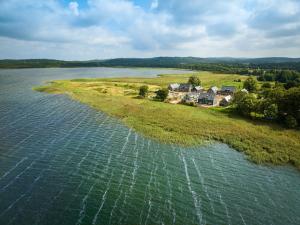 eine Luftaufnahme einer Insel in einem Gewässer in der Unterkunft Ferienhaus am See LEE - Vogteihof am Bodden in Streu