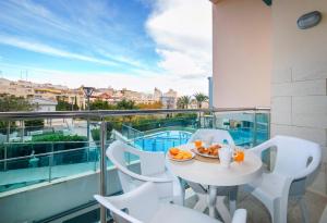 a white table and chairs on a balcony with a view at Homeincalpe Borumbot in Calpe