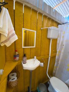 a bathroom with a sink and a toilet and a mirror at Casa de Praia LUÁ in Bragança