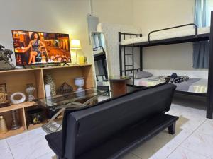 un soggiorno con divano, TV e letti a castello di Basic Private Room with attached bathroom - No Parking Space a Abu Dhabi