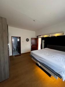 een slaapkamer met een groot bed en een badkamer bij DK Homes in Bunamwaya