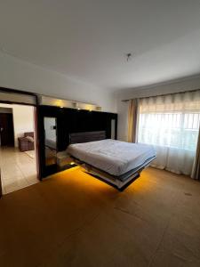 een slaapkamer met een bed en een groot raam bij DK Homes in Bunamwaya