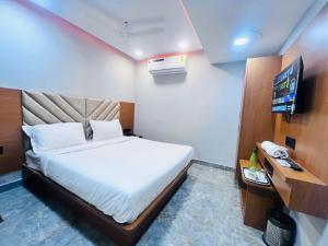 a bedroom with a bed and a television in it at Hotel Sun Lake in Ahmedabad