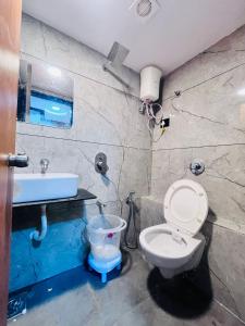 a bathroom with a toilet and a sink at Hotel Sun Lake in Ahmedabad +14 photos