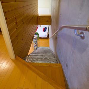eine Treppe in einem Zimmer mit einem Bett in einem Zimmer in der Unterkunft Grand Reve KODEKI in Yadachō