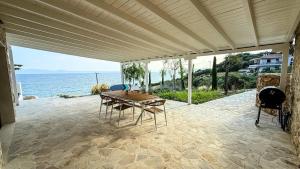 een terras met een tafel en stoelen en de oceaan bij Eosea Selene in Ierissos